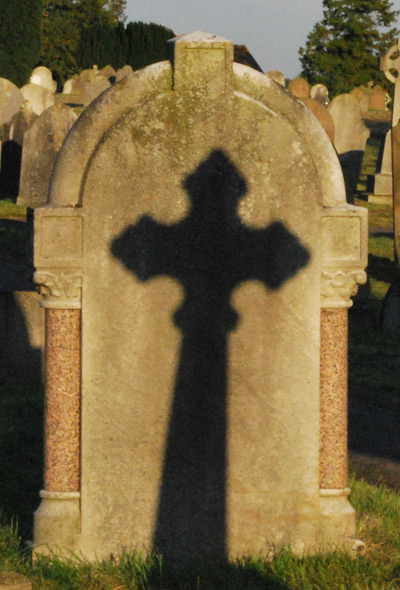 The shadow of one gravestone falls on another